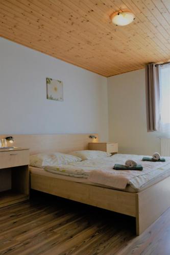 a bedroom with a large bed with a wooden ceiling at Guest house Fleurs in Liptovský Mikuláš