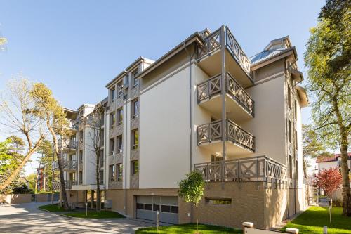 a building with balconies on the side of it at Rezydencja Park - City Apartments in Mielno