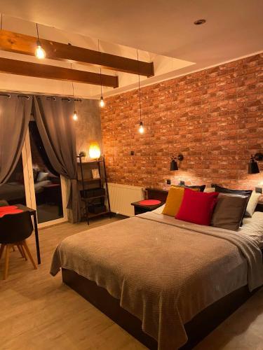 a bedroom with a large bed and a brick wall at Pokoje Alicja in Łeba