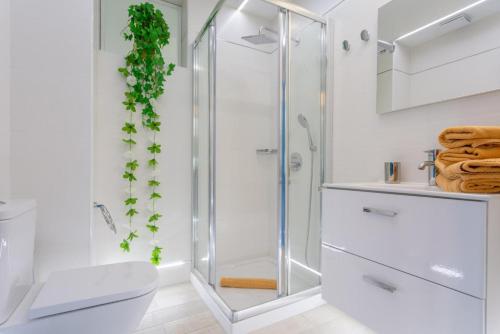 a white bathroom with a shower and a toilet at Villa Angela in Mácher