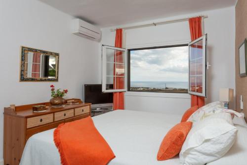 um quarto com uma cama e uma grande janela em Villa Angela em Mácher