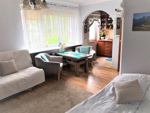 a living room with a table and chairs and a bed at Ania in Ustka