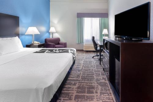 a hotel room with a bed and a flat screen tv at La Quinta by Wyndham Kerrville in Kerrville