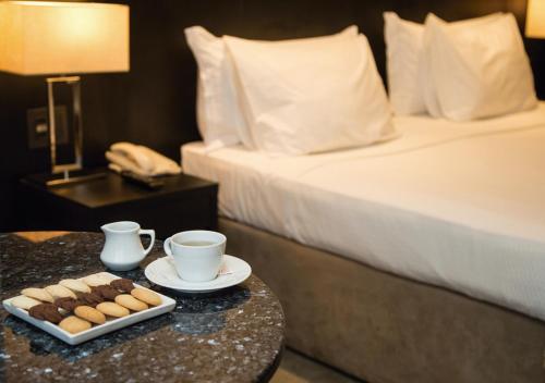 a hotel room with a bed and a tray of pastries on a table at Windsor Leme Hotel in Rio de Janeiro