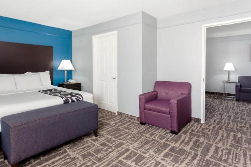a hotel room with a bed and a chair at La Quinta by Wyndham Kerrville in Kerrville