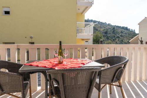 een tafel met een fles wijn op een balkon bij Villa Antonia in Rogoznica