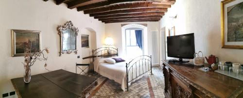 a bedroom with a bed and a tv in a room at Angolo Del Poeta in Bergamo