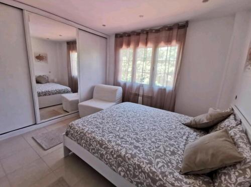 a bedroom with a bed and a chair and a mirror at villa Santa Ana in Laredo