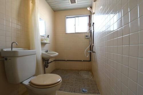 La salle de bains est pourvue de toilettes, d'un lavabo et d'une fenêtre. dans l'établissement Onsen Inn Hamayu Nagi / Vacation STAY 81903, à Beppu