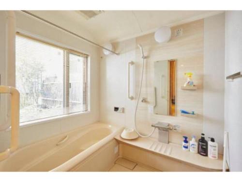 a bathroom with a tub and a sink and a mirror at Shinjuku Garden House / Vacation STAY 81151 in Tokyo