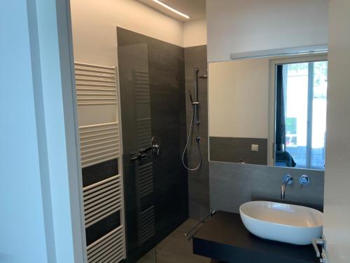 a bathroom with a sink and a shower with a mirror at Apartments Sabine K in Merano