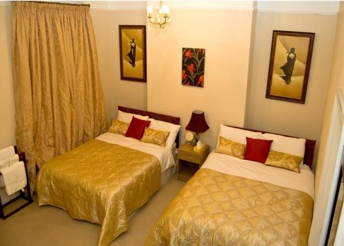 sypialnia z dwoma łóżkami ze złotą pościelą w obiekcie No 7 Priory Guest House w mieście Dover