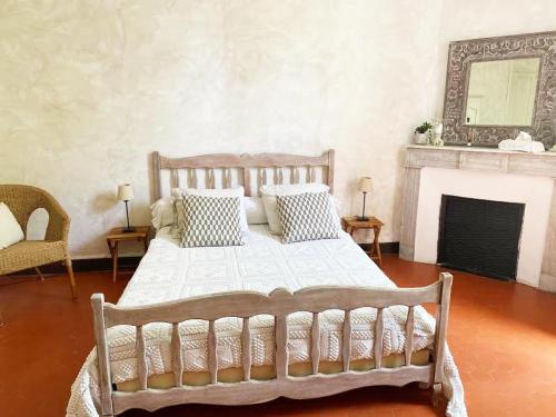 - une chambre avec un lit doté d'oreillers et une cheminée dans l'établissement Bed & Breakfast Chambres d'hôtes COTTAGE BELLEVUE, à Cannes