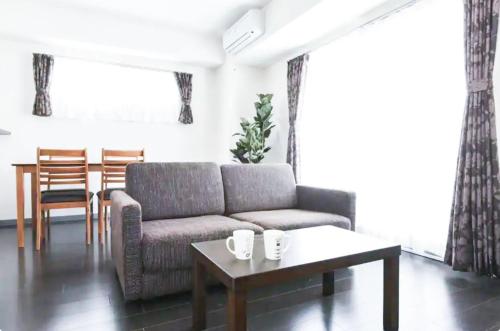a living room with a couch and a table at Suncourt Hondori Garden Hills / Vacation STAY 7593 in Sapporo
