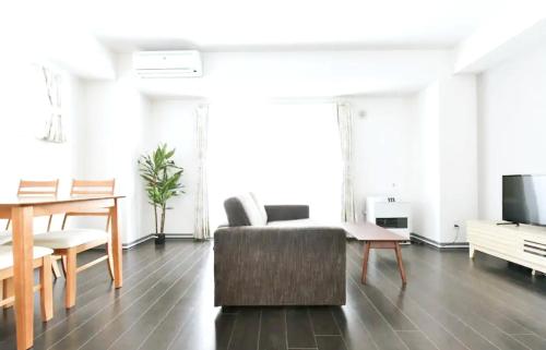 a living room with a couch and a table and a tv at Suncourt Hondori Garden Hills / Vacation STAY 7594 in Sapporo
