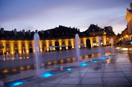 un groupe de fontaines devant un bâtiment dans l'établissement Appart Hotel Montchapet Dijon Centre, à Dijon