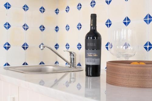 a bottle of wine sitting on a counter next to a sink at Aveiro History Apartments in Aveiro