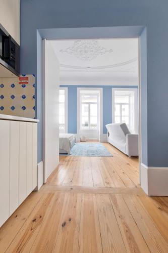 a living room with blue walls and a hard wood floor at Aveiro History Apartments in Aveiro