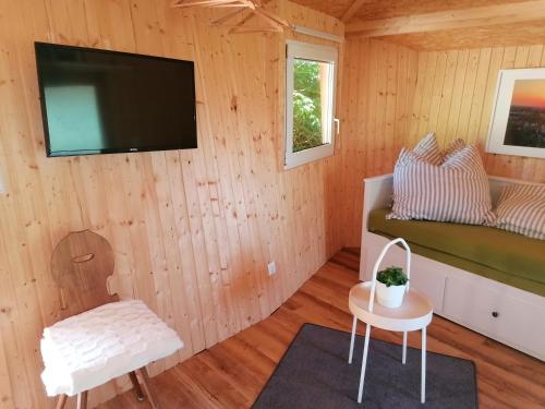 Kleines Zimmer mit einem Bett und einem TV an der Wand in der Unterkunft Baumhaus Freiburg in Freiburg im Breisgau