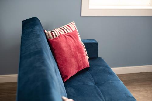 a blue couch with a red pillow on it at Aveiro History Apartments in Aveiro