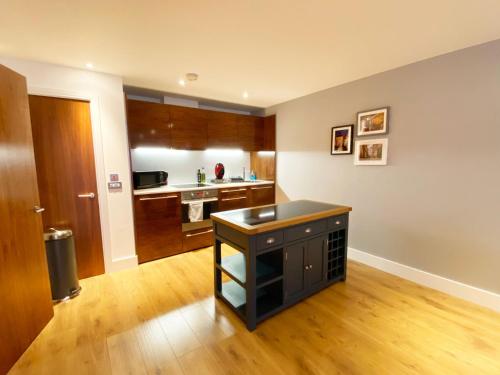 a kitchen with a black island in a room at Spacious Luxury Waterfront Apartment in Ipswich