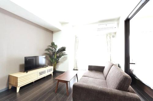 a living room with a couch and a flat screen tv at Suncourt Hongo Dori Garden Hills / Vacation STAY 7607 in Sapporo