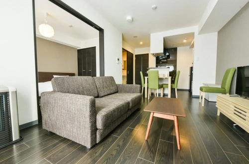 a living room with a couch and a table at Suncourt Hongo Dori Garden Hills / Vacation STAY 7608 in Sapporo