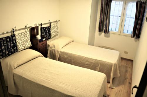 Habitación con 3 camas y sábanas blancas. en Le Case del Vento - APPARTAMENTO MAESTRALE, en Torre Canne