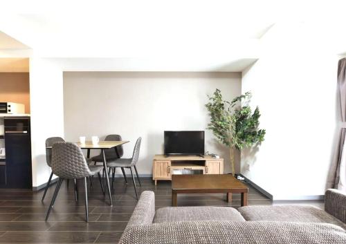 a living room with a couch and a table at Suncourt Hongo Dori Garden Hills / Vacation STAY 7609 in Sapporo