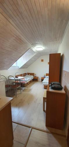 a room with two beds and a table and chairs at Ubytovanie LISKA in Radava