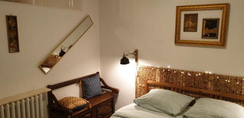 une chambre avec un lit, un miroir et une chaise dans l'établissement Hier et Aujourd’hui 21, à Malakoff
