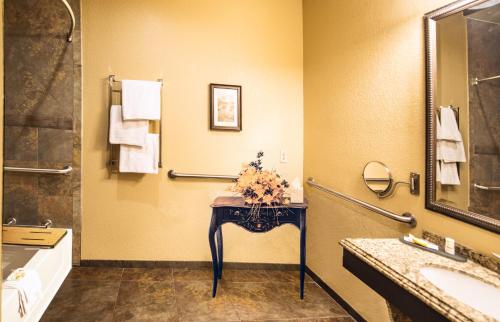 a bathroom with a sink and a table with flowers on it at La Quinta by Wyndham Marble Falls in Marble Falls