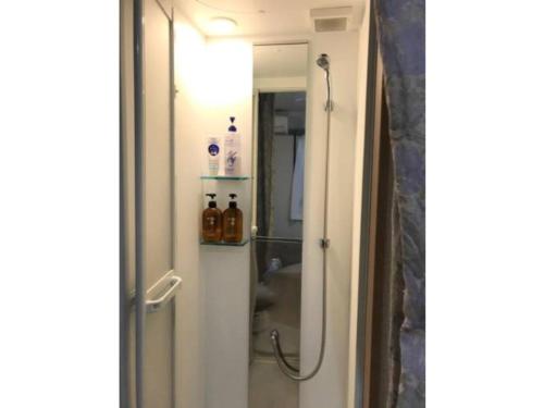 La salle de bains est pourvue d'une douche avec une porte en verre. dans l'établissement Sadie's Home / Vacation STAY 7575, à Kawasaki