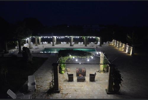 a swimming pool with lights in a yard at night at Bed & breakfast vecchia vallata in Gioia del Colle
