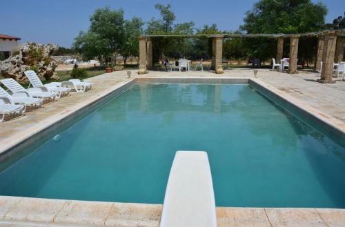 a large swimming pool with chairs at Bed & breakfast vecchia vallata in Gioia del Colle