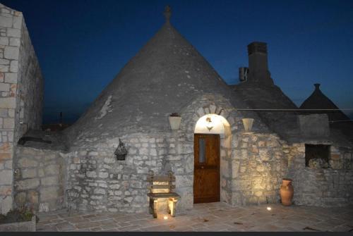 an old stone building with a wooden door with lights at Bed & breakfast vecchia vallata in Gioia del Colle