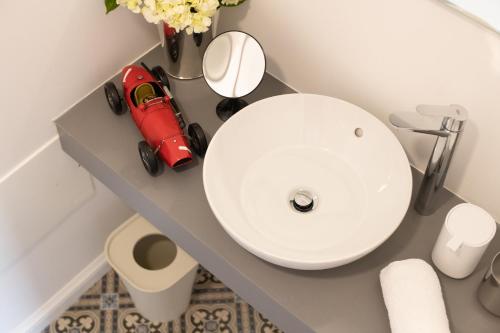 a bathroom with a white sink and a red car on a counter at Aveiro History Apartments in Aveiro
