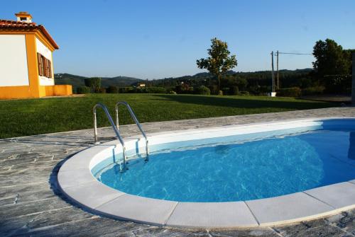 a swimming pool in the backyard of a house at Casa da Eira em Dornes - Casa de campo familiar com piscina in Dornes
