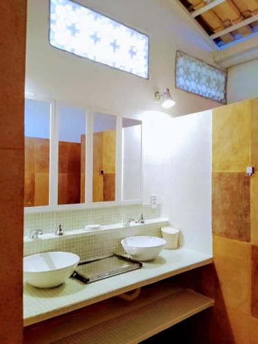 a bathroom with two sinks and a large mirror at Castelo Vendôm Ecolodge Parajuru in Parajuru