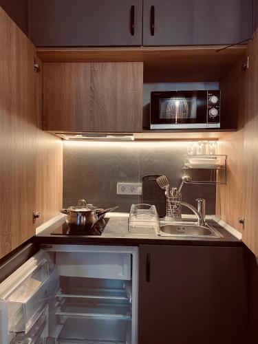a kitchen with a sink and a microwave at Mykonos Hotel Apart - Maestro in Odesa