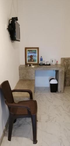 a living room with a chair and a tv at Kutumbaya in Anuradhapura