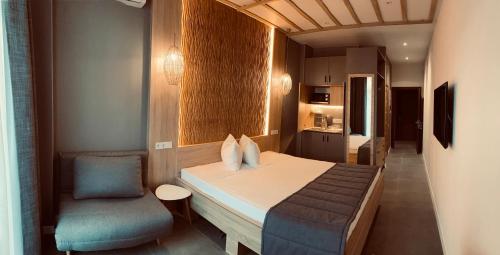 a small bedroom with a bed and a chair at Mykonos Hotel Apart - Maestro in Odesa