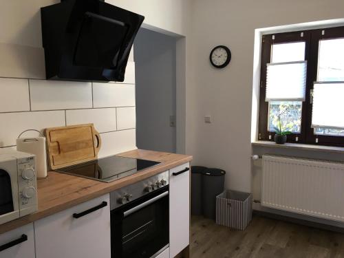 uma cozinha com fogão e uma televisão na parede em Ferienwohnungen Stadtgeflüster em Cochem