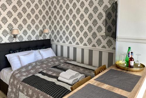 a small bedroom with a bed and a table with towels at VULTOR Apartments in Wrocław
