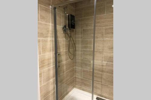 uma casa de banho com um chuveiro e uma porta de vidro em Bright, stylish Studio flat with Sky Sports em Earley