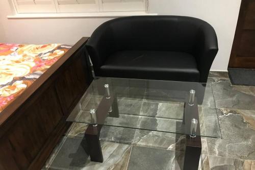 a black chair sitting on top of a glass table at Bright, stylish Studio flat with Sky Sports in Earley