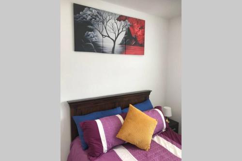 a bedroom with a bed with colorful pillows at Bright, stylish Studio flat with Sky Sports in Earley