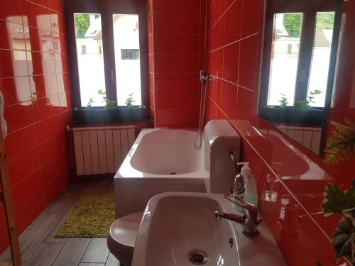 un bagno rosso con lavandino e vasca di Thirsty River Rooms a Bovec