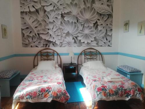 two beds in a room with a wall mural at Apartamento Patricia in Hermigua
