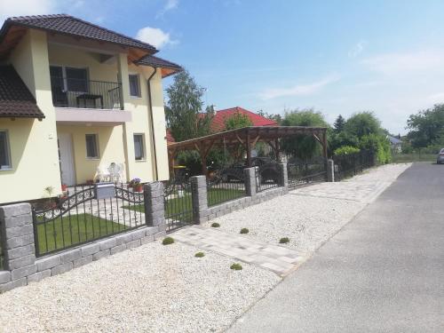 a fence in front of a house at Villa Katalino in Gyenesdiás